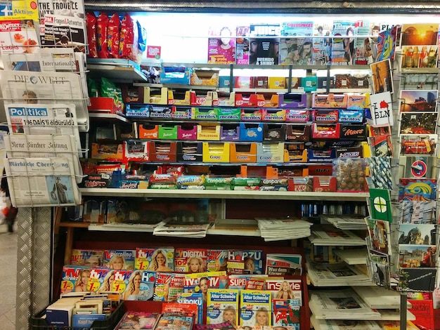 A cluttered game store, with shelves full of used physical game cartridges and discs, and customers browsing through the selection.