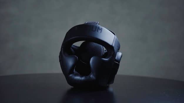 A close up photo of a high-end gaming headset with plush earcups and a retractable microphone, resting on a stand next to a gaming console, highlighting comfort and audio quality.